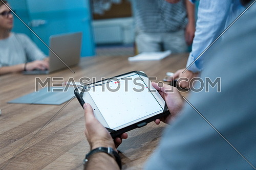 close up of businessman hands using tablet computer  on start up business meeting