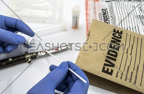 Scientist examines tests of cutting weapon of crime in a laboratory, conceptual image