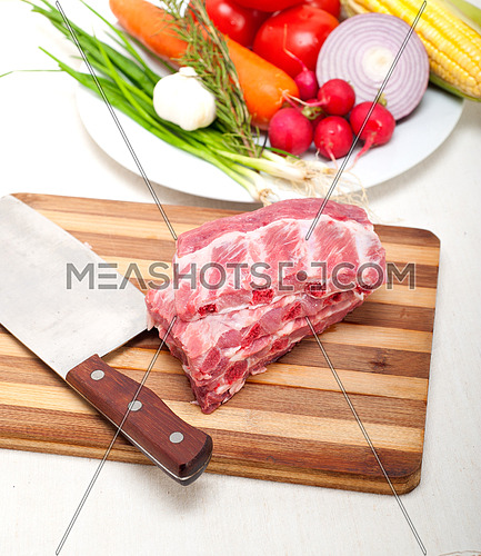 chopping fresh pork ribs with vegetables and herbs ready to cook