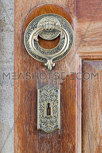 Closeup of antique copper ornate door knocker over an aged wooden door, Fatih Mosque, Istanbul, Turkey
