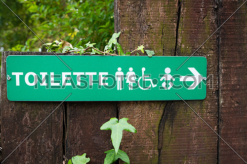 Green direction sign toilette, men ,women,kids and disabled.