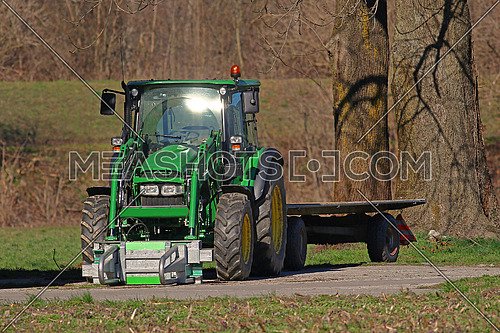 Green tractor and flatbed trailer