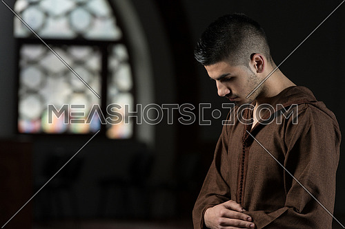 Young Muslim Man Making Traditional Prayer To God While Wearing A Traditional Cap Djellaba