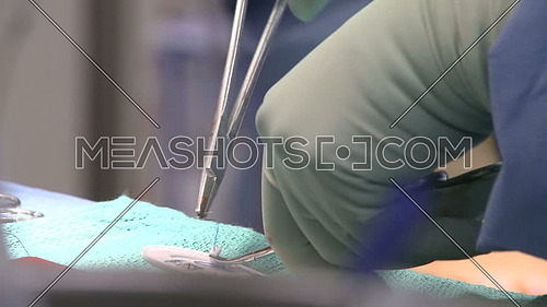 Close up shot for hand preparing Surgical suture on needle holder