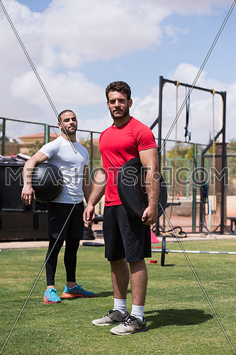 Young middle eastern athletic people exercise weightlifting outside on a sunny day