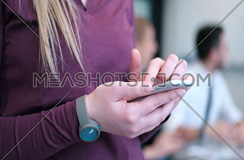 Close up of business woman using cell phone in office interior