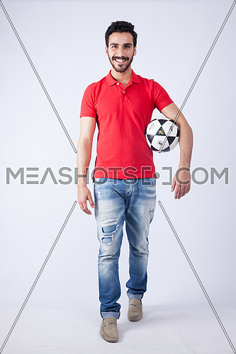 A young man wearing red t-shit and holding a football on a white background