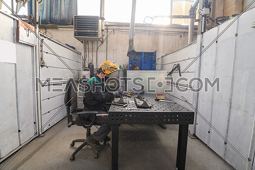 Metal industry worker working in a factory, wearing a protective face mask during coronavirus or covid19 pandemic. . High quality photo