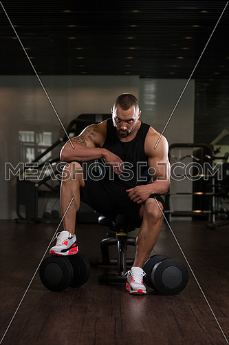 Beard Bodybuilder Resting At The Bench In A Gym