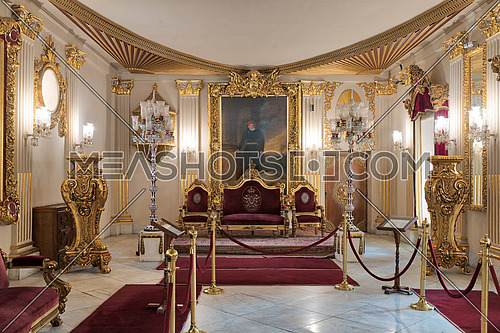 Throne Hall at Manial Palace of Prince Mohammed Ali with gold plated red armchairs, antique floor lamps, ornate ceiling and red carpets, Cairo, Egypt