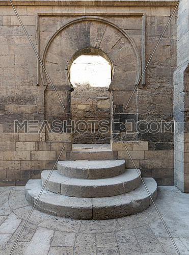 Wooden aged vaulted open door, three steps and stone wall, Medieval Cairo, Egypt