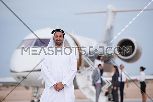 Portrait of a young Arab successful businessman in front of private airplane