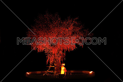 red chinese new year tree with small statue illuminated with red light