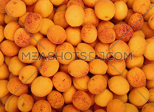 Fresh ripe mellow apricots background pattern close up, top view