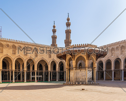 Ablution fountain mediating the courtyard of public historic mosque of Sultan al Muayyad, with background of arched corridors surrounding the courtyard, and minarets of the mosque, Cairo, Egypt