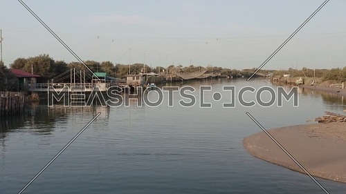 Fishermen huts with fishing nets and fishing equipment on the river at morning,Lido di Dante, Fiumi Uniti, Ravenna near Comacchio valley.