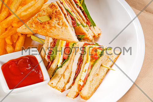 fresh triple decker club sandwich with french fries on side