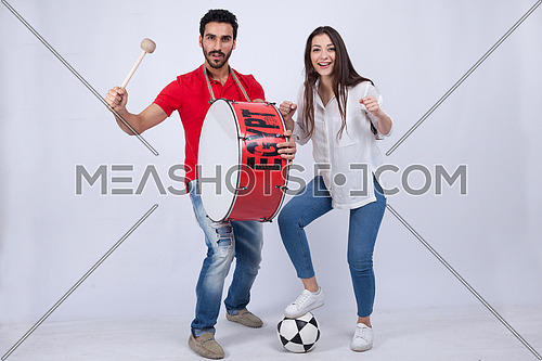 A young man holding big drums and a young woman cheering on a white background