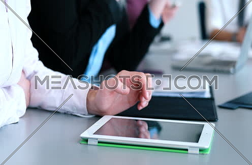 Close up shot for young man hands using his tab at meeting room interior