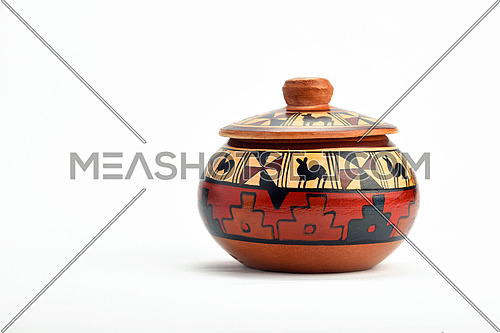 Painted handmade traditional Latin American ceramic pot with closed lid isolated on white background