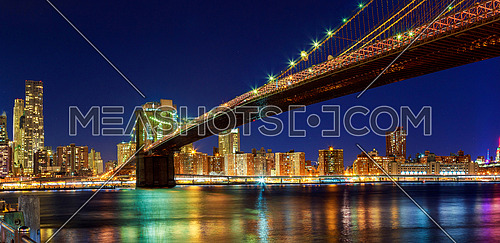 New York - Panoramic view of Manhattan Skyline with skyscrapers and famous Brooklyn Bridge by night, big size