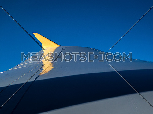 Plane wing during flight with blue skyes
