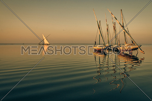 sail boats parked in the middle of a lake