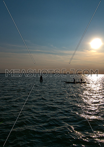 Italy Venice lagune view from  Burano island at sunset with boat silouette