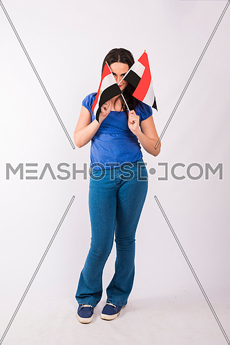 Young lady standing and holding two small egyptian flags on white background.