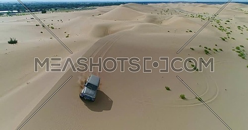 A car moving through sand dunes in the desert