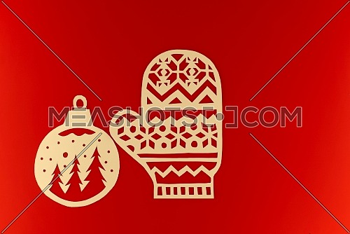 New Year and Christmas flat lay on festive red background with paper cut gloves and ball ornament with copy space for text