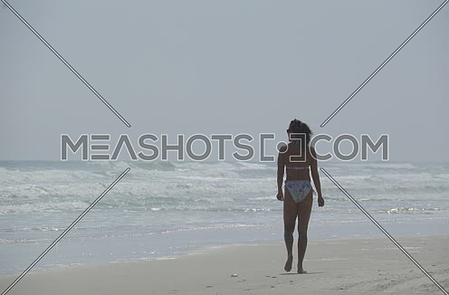 a woman walking by the beach on florida