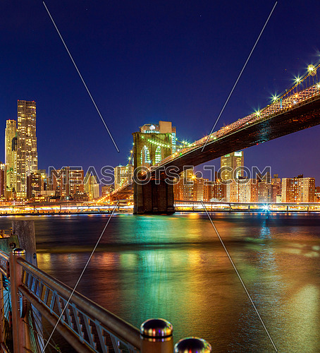 Brooklyn Bridge and Manhattan Skyline At Night, New York City Hudson River with skyline after sunset night view illuminated with lights viewed from Brooklyn.
