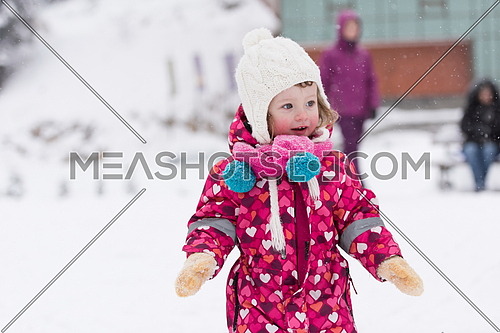 portrait of happy smiling little girl child outdoors having fun and playing on snowy winter day
