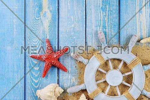Captain steering wheel on shells and starfish on rustic wood border