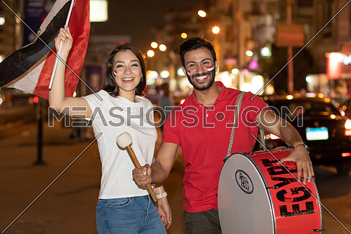 Egyptian football supporters in the street with Egyptian flag and a drum at night