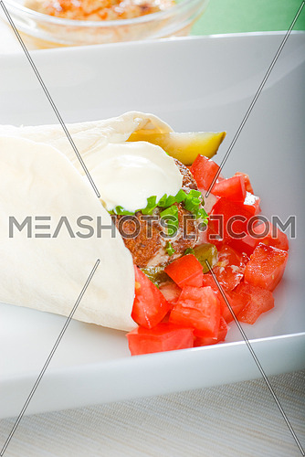 fresh traditional falafel wrap on pita bread with fresh chopped tomatoes