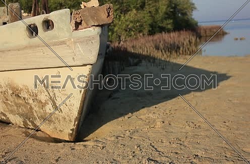 Close Shot for an Old wodden boat on the seashore with green tress in background at Wadi Lahmi at Day - 5D
