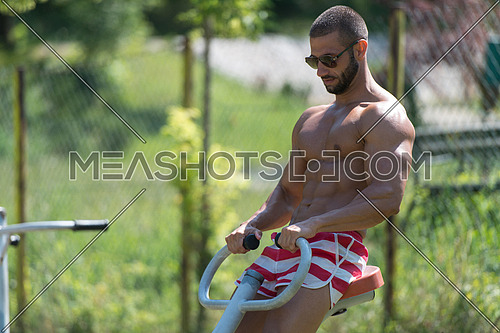 Handsome Muscular Young Man - Training On The Playground In Park