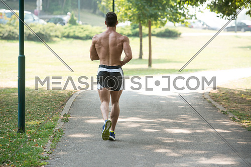 Young Bodybuilder Running In Park Area - Training And Exercising For Trail Run Marathon Endurance - Fitness Healthy Lifestyle Concept