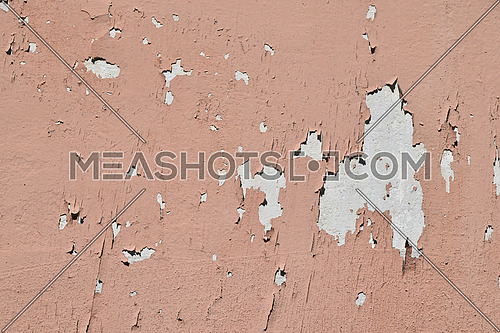 Vintage flakes of old faded pink paint over abandoned grey concrete wall