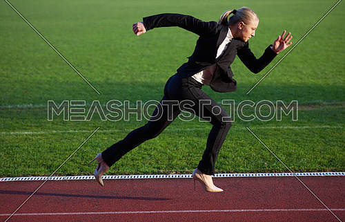business man in start position ready to run and sprint on athletics racing track
