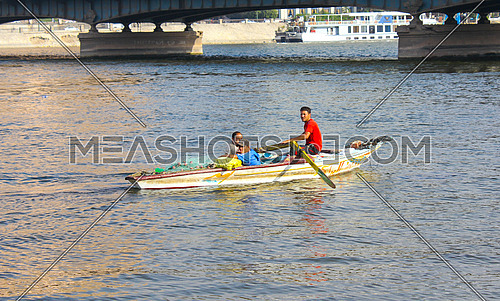 3 fisher men in a small fishing boat in the river nile