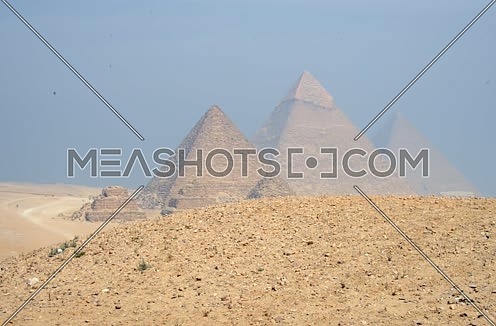 Man riding horse pass infront of pyramids