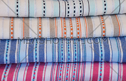 Close up colorful linen textile towels, beach mat coverlets and bedspreads on retail display