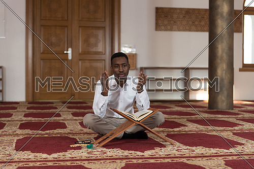 Black African Muslim Man Is Reading The Koran