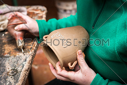 Potter decorating a ceramic jar with the word honey, clay pottery ceramics typical of BailÃ©n, Jaen province, Andalucia, Spain