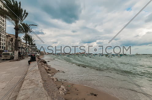 Fixed Shot for sea shore showing fishing boats and street at alexandria at day