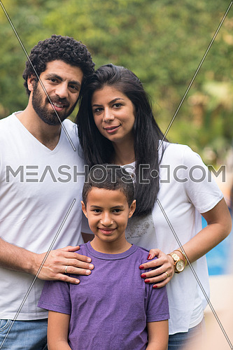 Portrait of a young middle east couple with their son in the yard by the pool