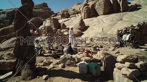 Follow shot for bedouins get water from Ain hudra at Sinai Mountain at day.